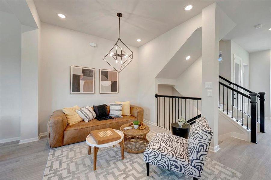 Living area with light wood-finish flooring and recessed lighting