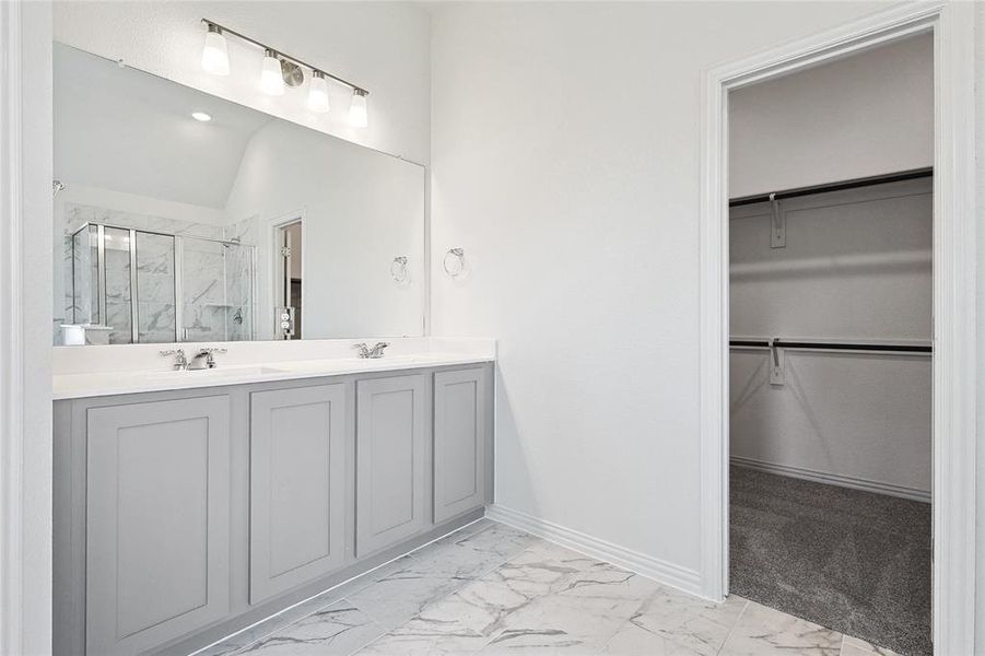 Bathroom with tile patterned flooring, vanity, vaulted ceiling, and walk in shower