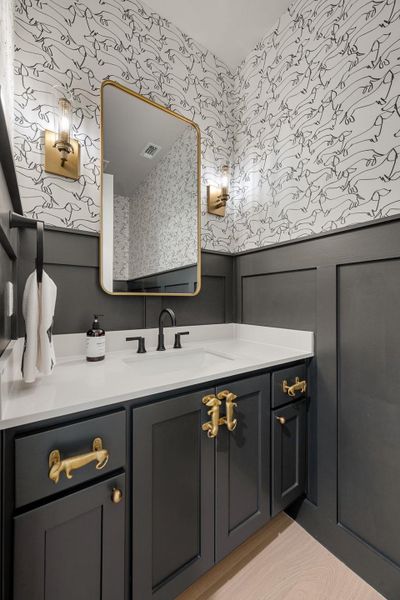 Striking wainscoting and custom hardware define this beautifully appointed powder room.