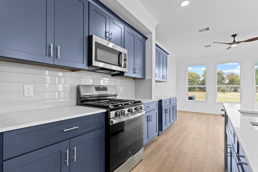 This wonderful gourmet kitchen has tall, beautiful custom shaker cabinets with chic subway backsplash and more!