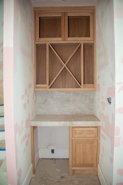 White oak bar with a luxurious Taj Mahal quartzite countertop and full backsplash