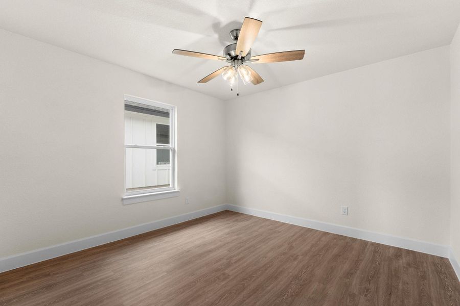 Empty room featuring wood finished floors and ceiling fan
