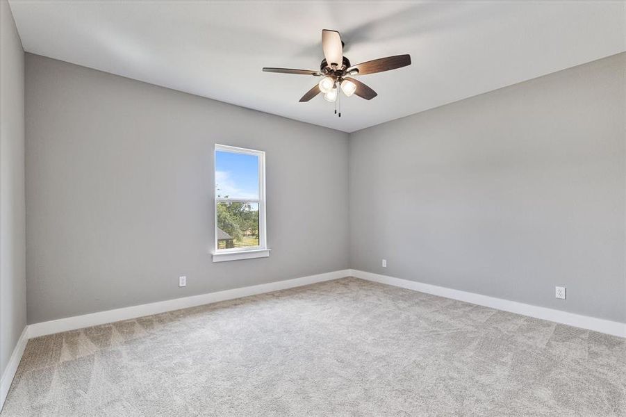 Carpeted spare room featuring ceiling fan