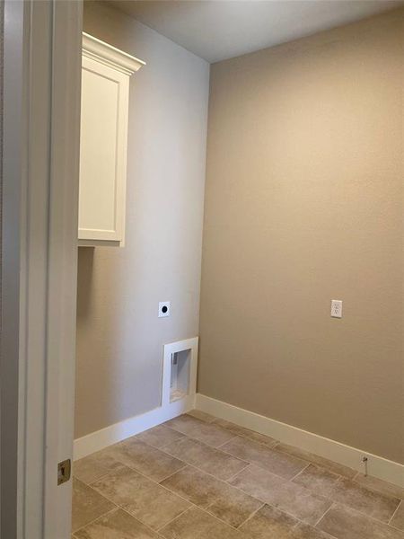 Clothes washing area with cabinets and electric dryer hookup