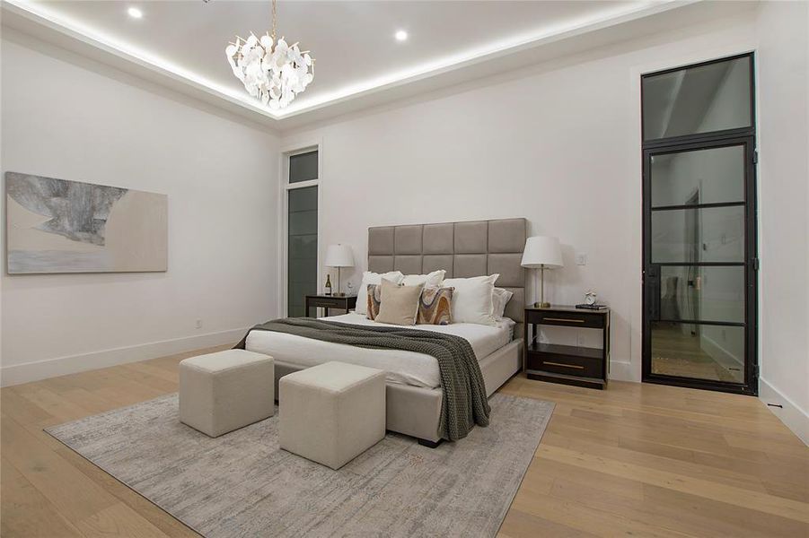 Bedroom with light wood-type flooring and an inviting chandelier