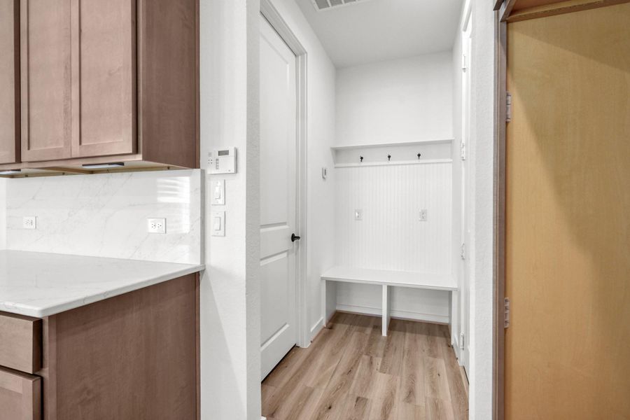 Off the kitchen and entry to the garage is this drop zone and walk-in pantry.