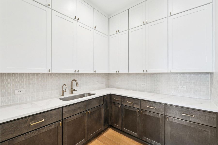 Back Kitchen with decorative backsplash, dark brown cabinets, and white cabinets