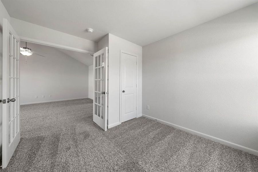 Unfurnished bedroom with a closet, carpet floors, ceiling fan, and french doors