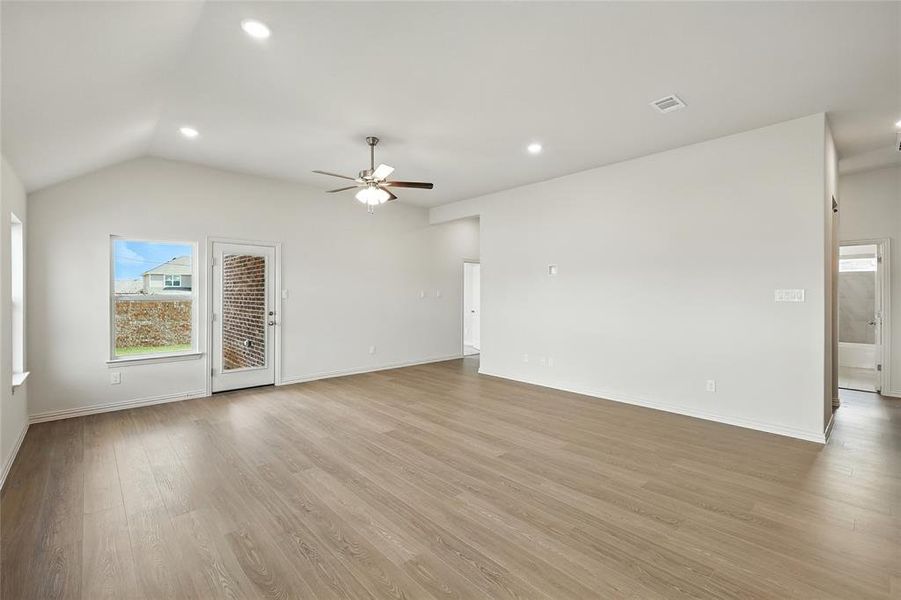 Unfurnished living room with recessed lighting, light wood-type flooring, vaulted ceiling, and ceiling fan Unfurnished living room with recessed lighting, light wood-type flooring, vaulted ceiling, and ceiling fan