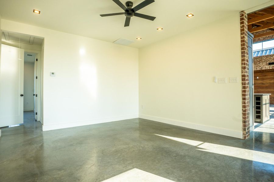 Empty room featuring attic access, concrete flooring, ceiling fan, and recessed lighting