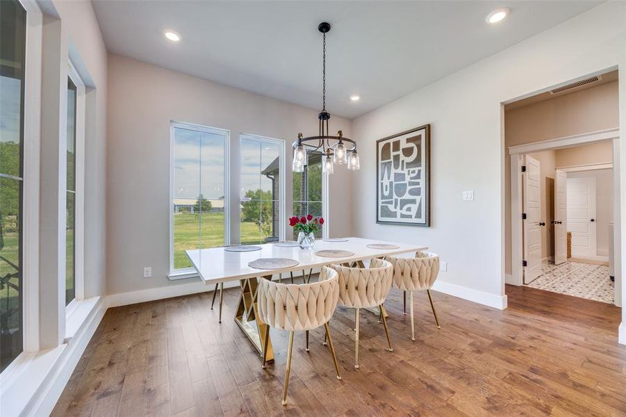 Dining area with light wood-type flooring, recessed lighting, and a chandelier