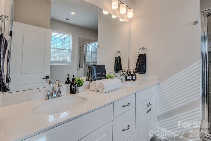 The bright and modern primary bathroom features a spacious vanity with ample counter space and a walk-in shower, offering both style and everyday functionality. The bright and modern primary bathroom features a spacious vanity with ample counter space and a walk-in shower, offering both style and everyday functionality.