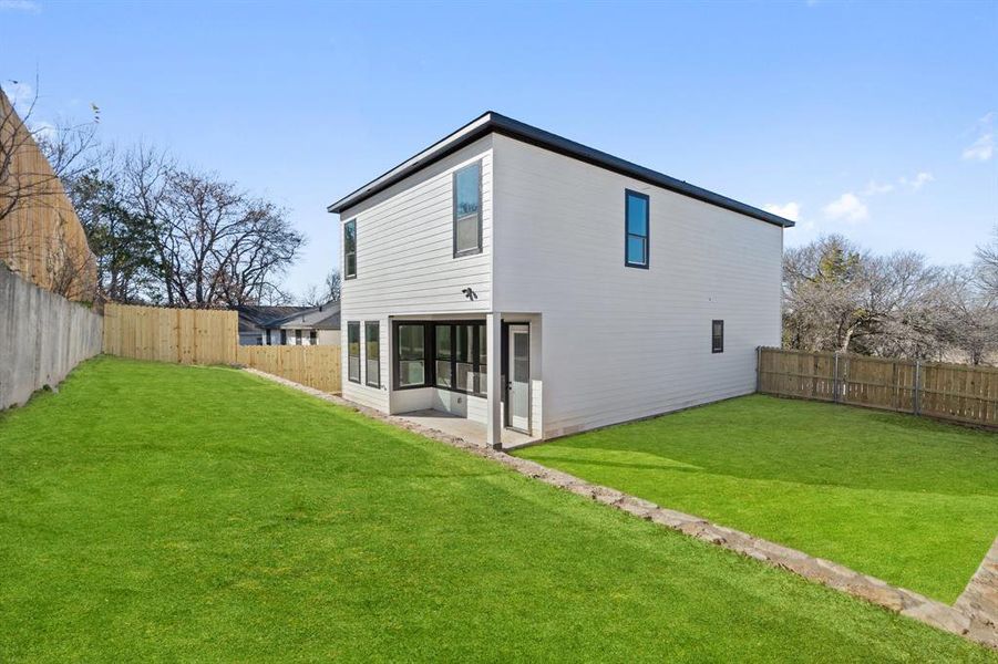 Rear view of property featuring a lawn