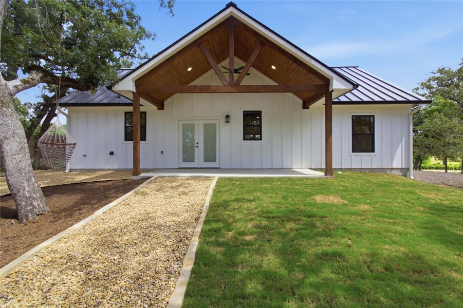 A welcoming covered porch with exposed timber framing adorns the front of this modern white-sided home. A welcoming covered porch with exposed timber framing adorns the front of this modern white-sided home.