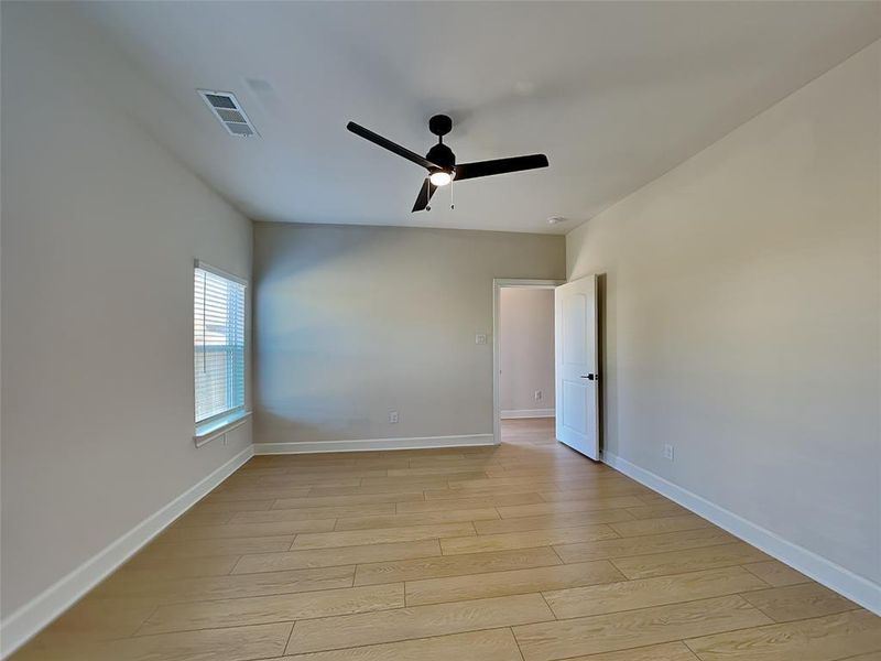 Unfurnished room with ceiling fan and light hardwood / wood-style floors