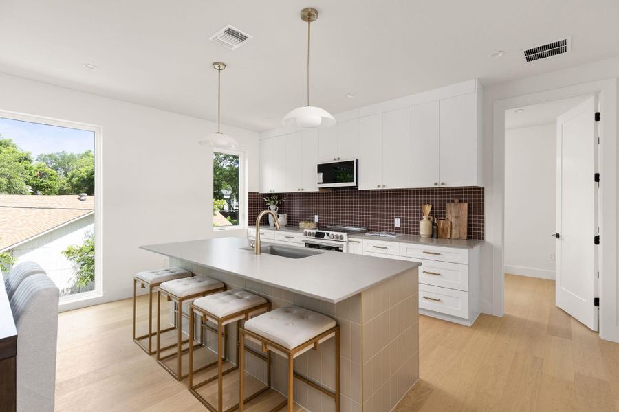 A sleek island kitchen featuring pristine countertops and ample storage, ideal for entertaining. A sleek island kitchen featuring pristine countertops and ample storage, ideal for entertaining.
