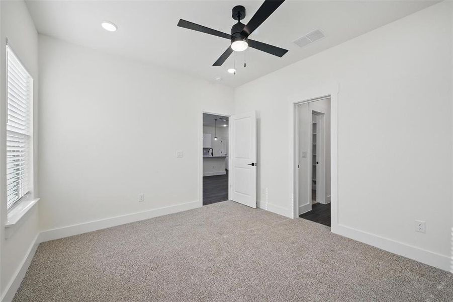 Unfurnished bedroom with visible vents, baseboards, ceiling fan, recessed lighting, and dark colored carpet Unfurnished bedroom with visible vents, baseboards, ceiling fan, recessed lighting, and dark colored carpet