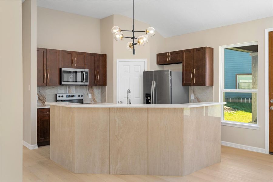The heart of the home shineswith a spacious island,modern lighting, andexpansive countertops,perfect for culinary creationsor casual dining.