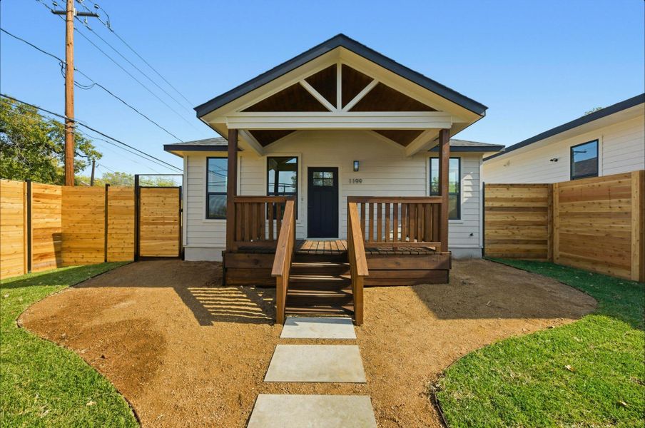 View of front facade with a fenced backyard and a porch