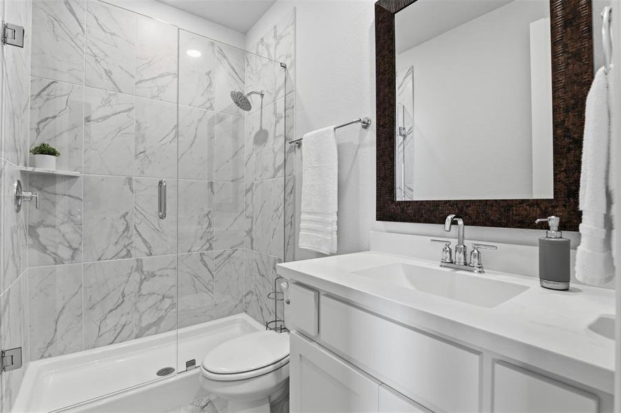 Full bathroom featuring a walk-in shower with clear glass enclosure and large format marble-look tile Full bathroom featuring a walk-in shower with clear glass enclosure and large format marble-look tile