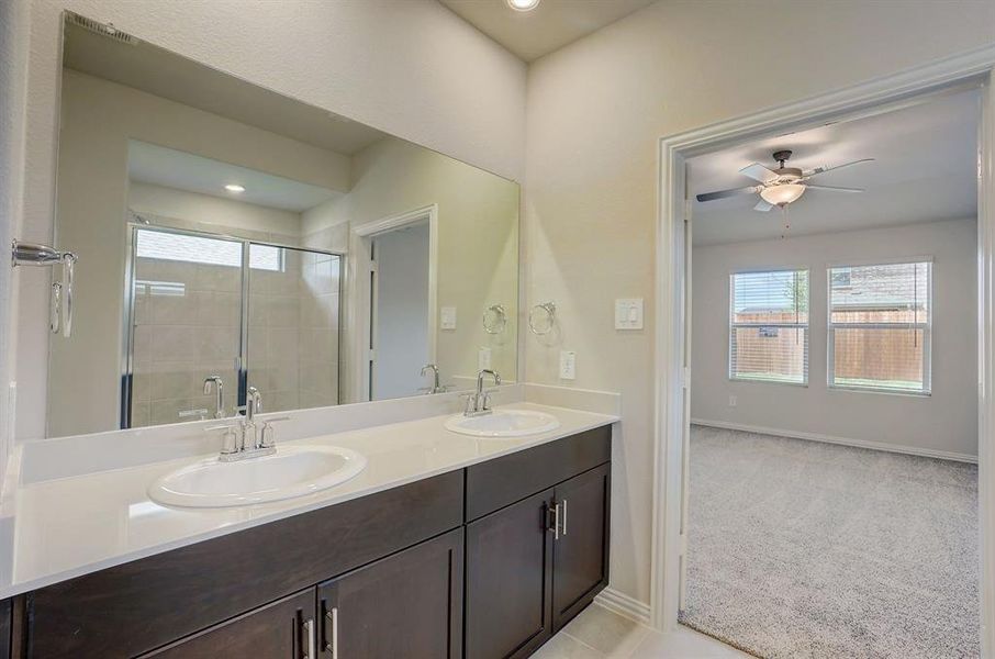 Bathroom featuring an enclosed shower, ceiling fan, tile patterned floors, and double sink vanity