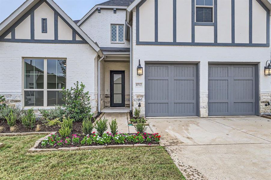 View of front of property featuring a front yard and a garage