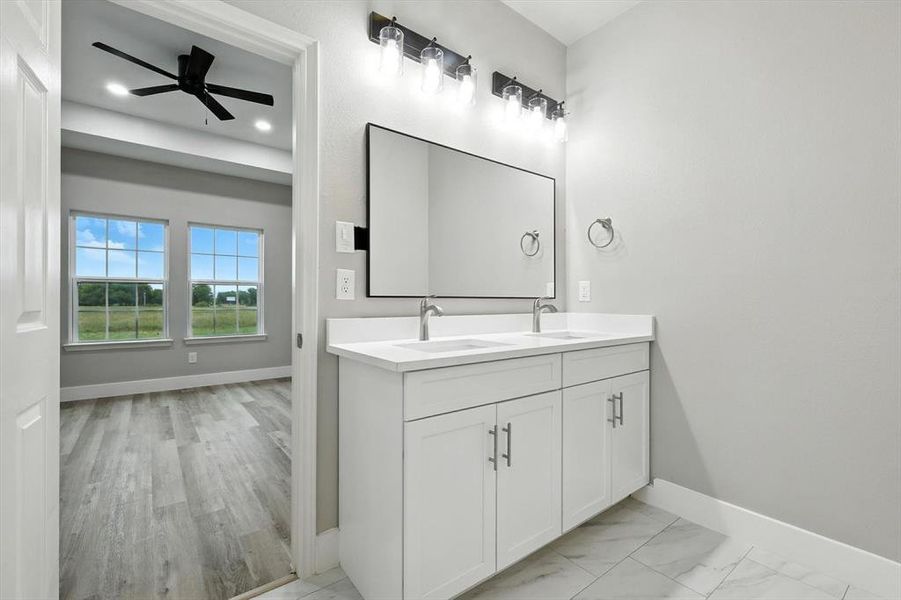 Bathroom featuring double vanity, ceiling fan, and light marble finish floors Bathroom featuring double vanity, ceiling fan, and light marble finish floors