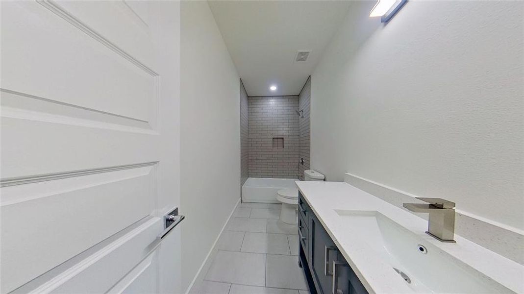 Bathroom with vanity,  shower combination, light tile patterned floors, and recessed lighting