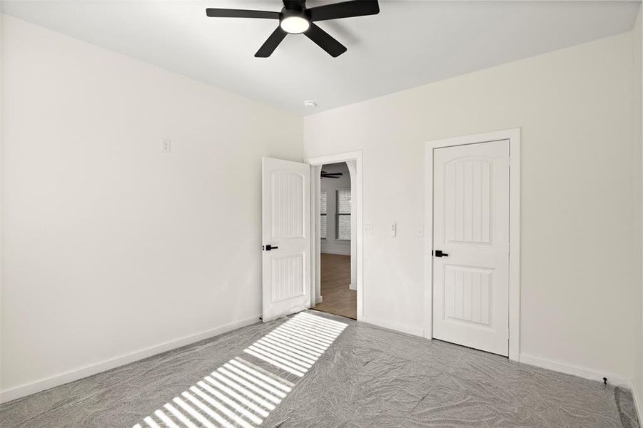 Unfurnished bedroom with carpet floors and ceiling fan
