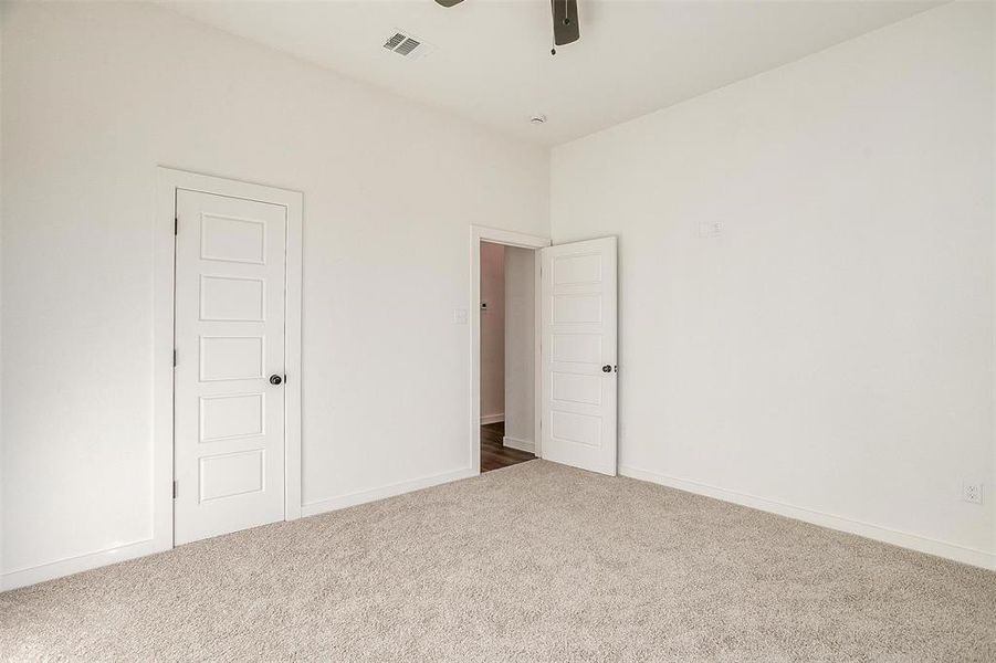 Carpeted empty room with ceiling fan