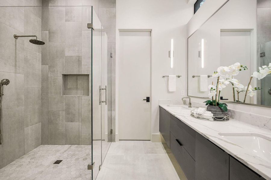 [EN-SUITE BATHROOM] Designed with both elegance and practicality in mind, the ensuite bath offers a spacious dual-sink vanity, a seamless glass walk-in shower and the rare luxury of two spacious walk-in closets