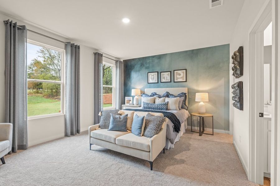 A room with a couch and a window with a view of the yard.