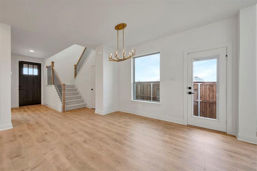 Foyer entrance featuring hanging lights and light wood-style floors