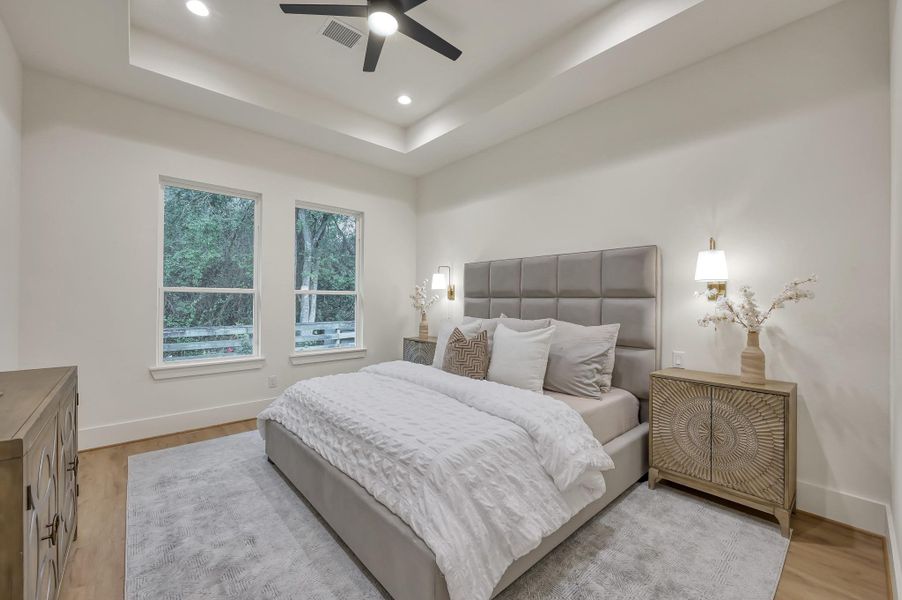 Primary bedroom w/built in reading lamps & tray ceiling. Primary bedroom w/built in reading lamps & tray ceiling.