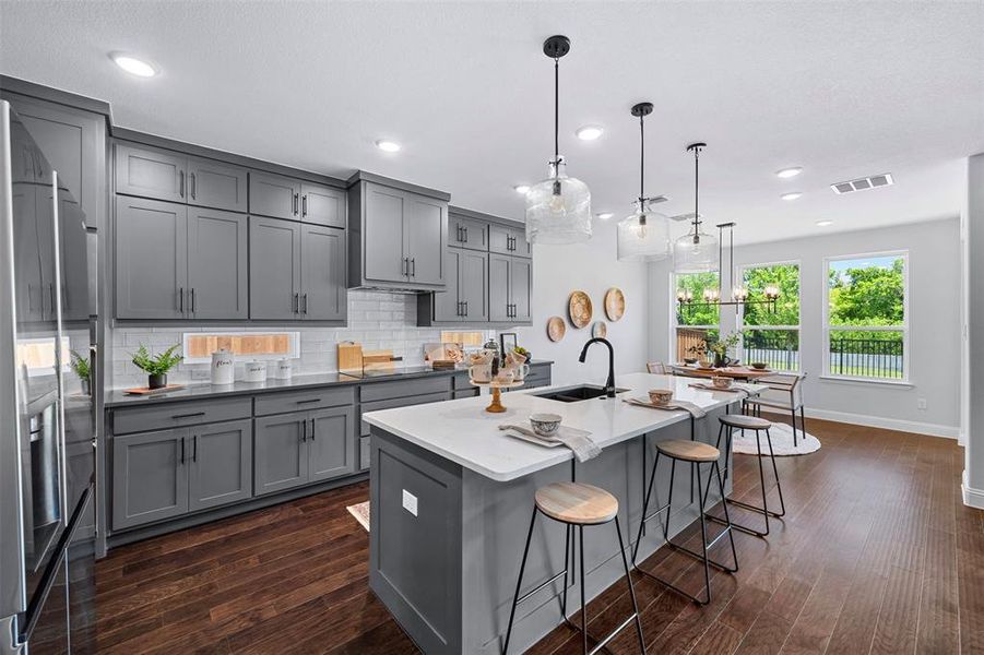 Kitchen featuring gray cabinetry, dark wood-type flooring, tasteful backsplash, high end fridge, and recessed lighting