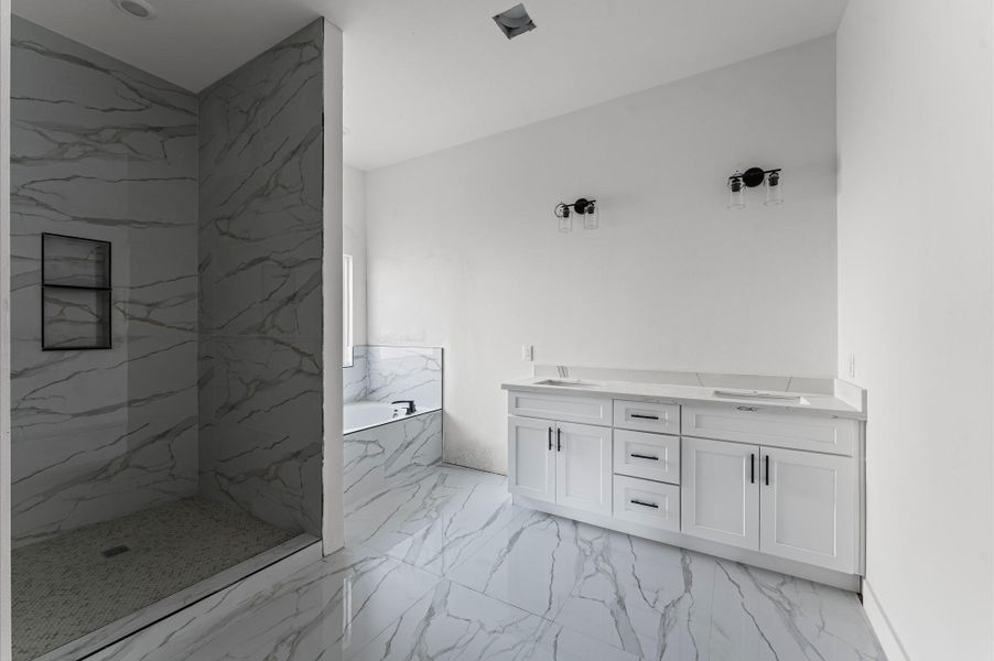 Luxurious bath with double-sink vanity, walk-in shower, and a relaxing soaking tub. Photos are representative of the same floor plan built by this builder. Finishes will be the same or similar.
