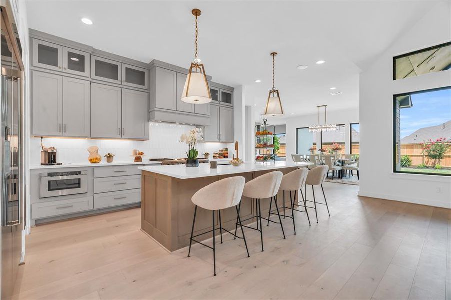 The kitchen features cabinets to the ceiling, some with glass inserts. There are plenty of drawers for storage, beautiful cabinet hardware, plus under cabinet lighting.