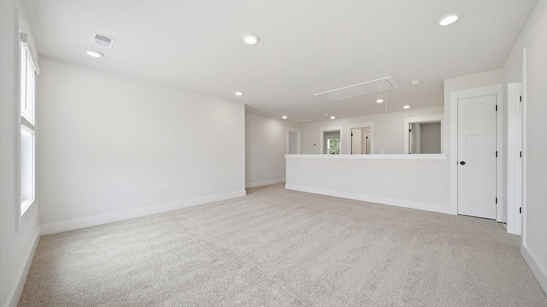 Superior loft space with soft carpet, ideal for work, relaxation, or entertainment at the Harrier Point community