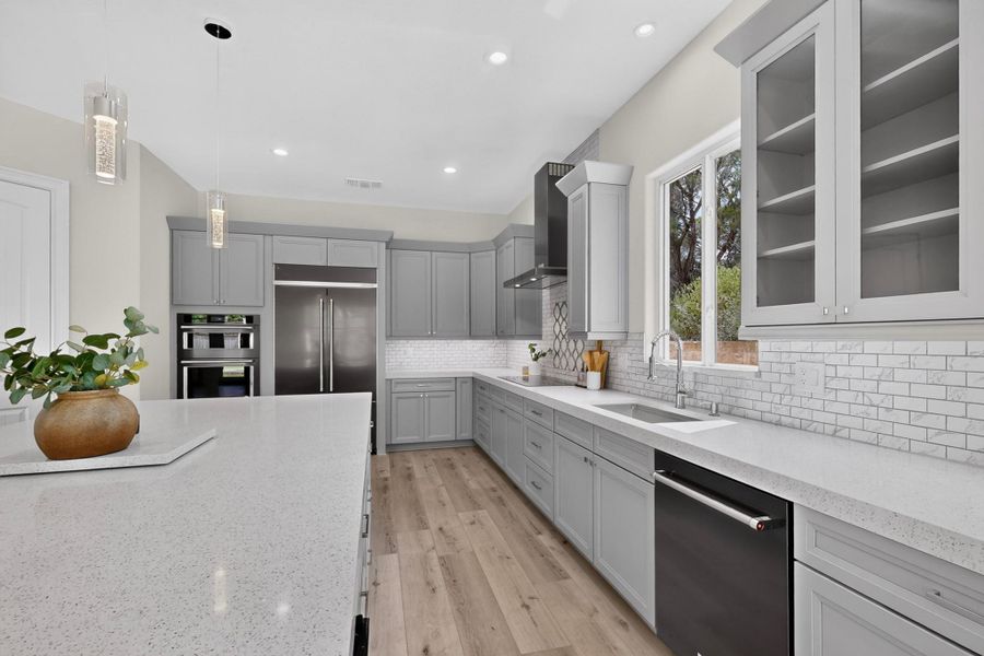 Gleaming stone countertops and classic wood floors anchors this beautifully designed cooking space.