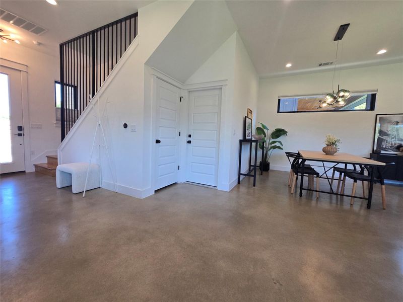 Polished concrete floors and crisp white walls define this light-filled dining space and entryway.