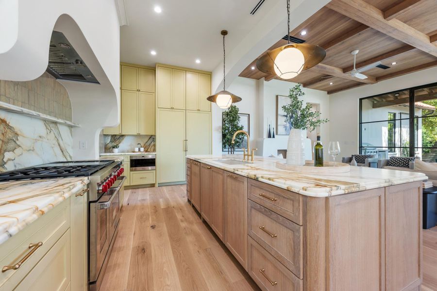 Rich wood plank floors and a stone-topped island ground this finely detailed culinary space.