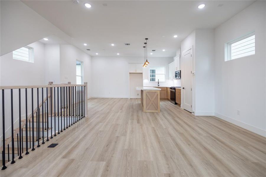 Alternate view of the open-concept living areas, featuring wood-like LVP flooring throughout, offering a sleek, carpet-free design.