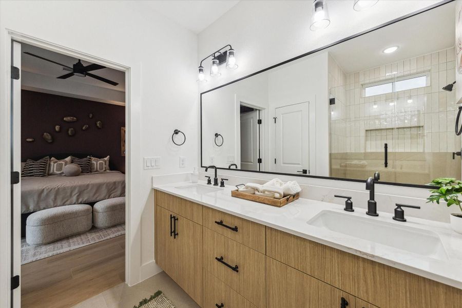 Primary bathroom showcasing oversized mirror and cabinetry Primary bathroom showcasing oversized mirror and cabinetry