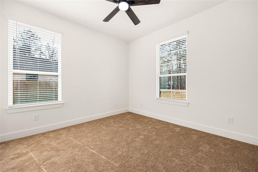 Bright and Airy BedroomThis spacious bedroom features large windows that bring in plenty of natural light, plush carpeting, and a modern ceiling fan. A cozy and inviting space perfect for rest and relaxation!