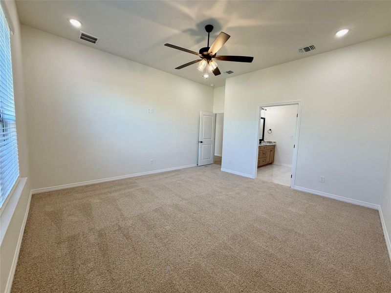 Unfurnished bedroom featuring recessed lighting, light colored carpet, a ceiling fan, and connected bathroom