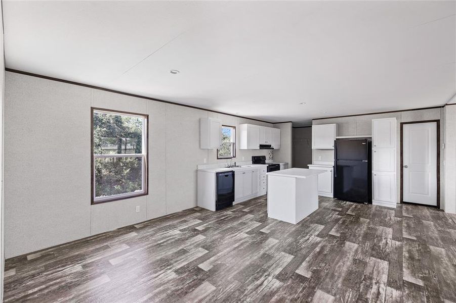 Kitchen featuring white cabinets, black appliances, sink, and a kitchen island