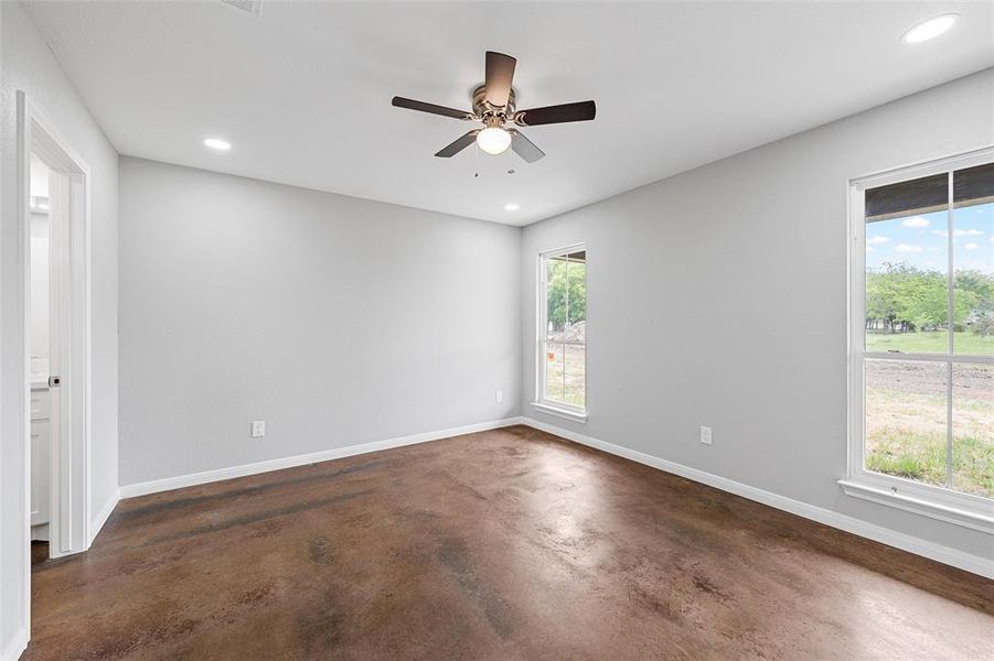 Spare room with a ceiling fan, concrete flooring, recessed lighting, and baseboards