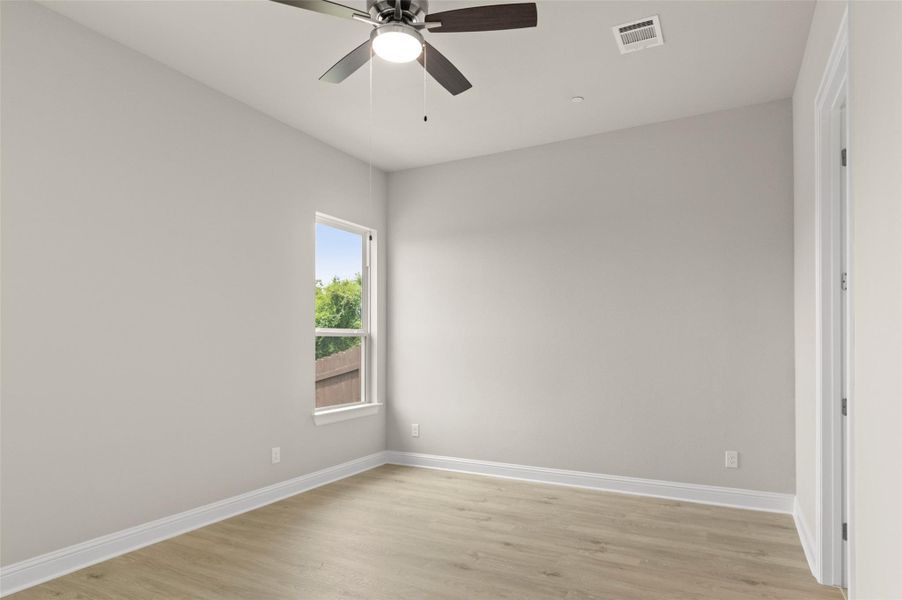 Spare room with baseboards, light wood-style flooring, and a ceiling fan