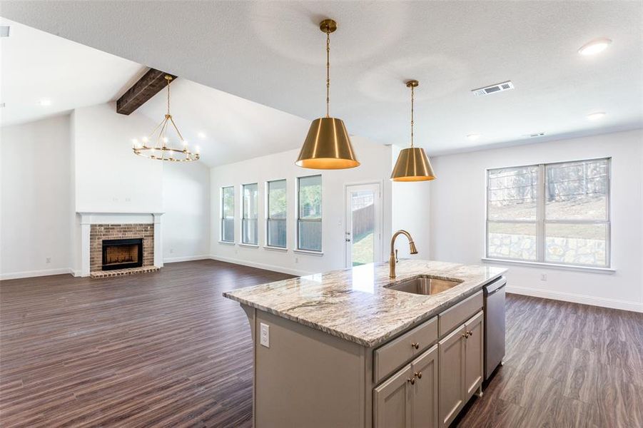 Kitchen with vaulted ceiling with beams, dark hardwood / wood-style flooring, gray cabinets, hanging light fixtures, and sink