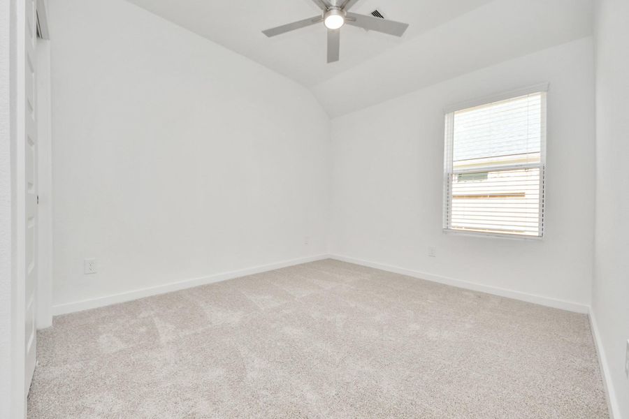 Secondary bedroom features plush carpeting, large windows that let in plenty of natural light, bright paint, and spacious closets.